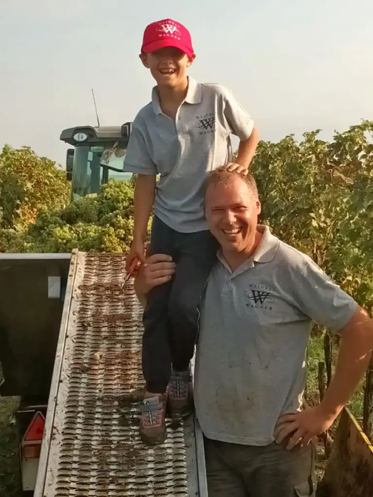 Reinhold Wagner und sein Sohn stehen während der Weinlese in einem Weinberg